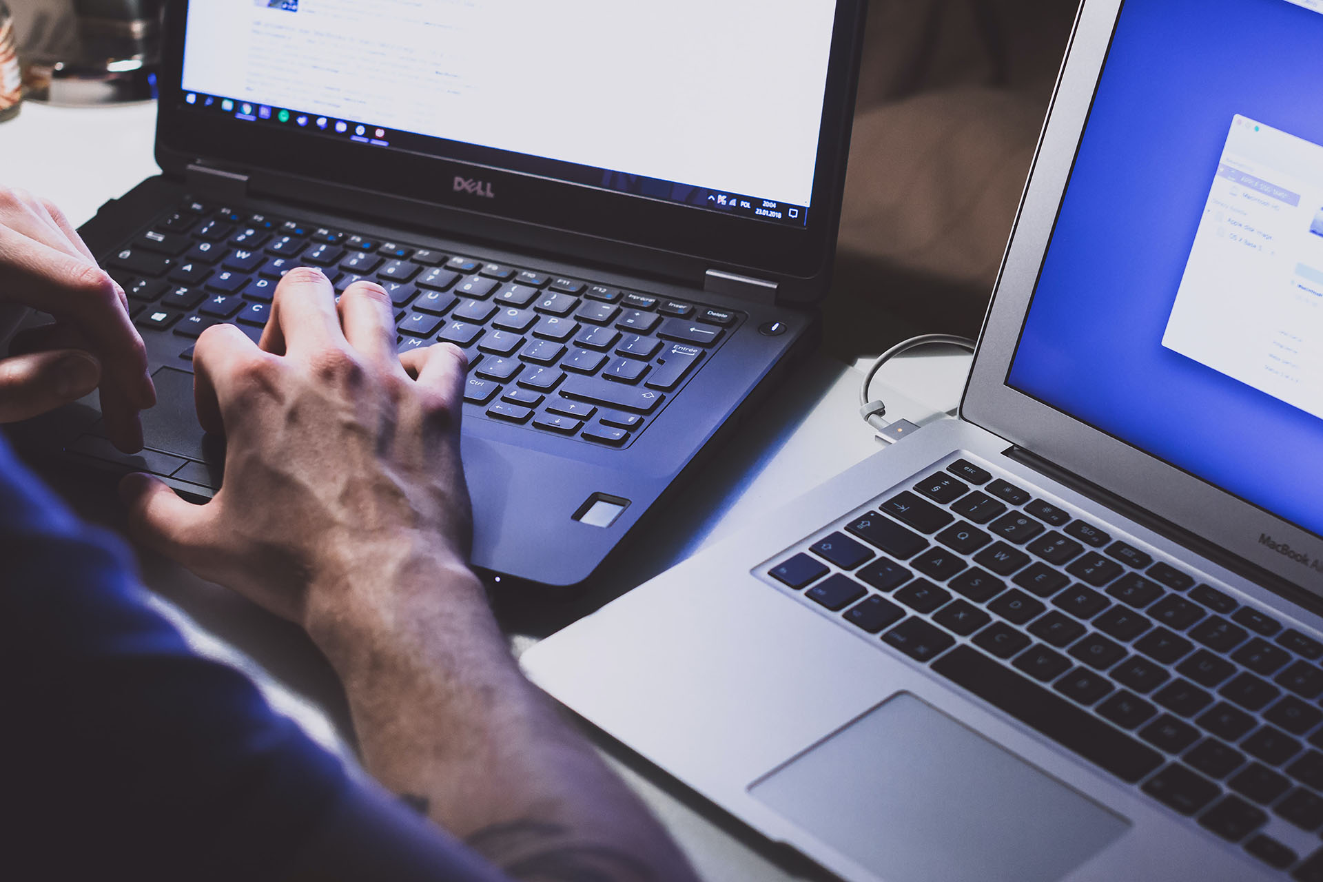 Person using two laptops